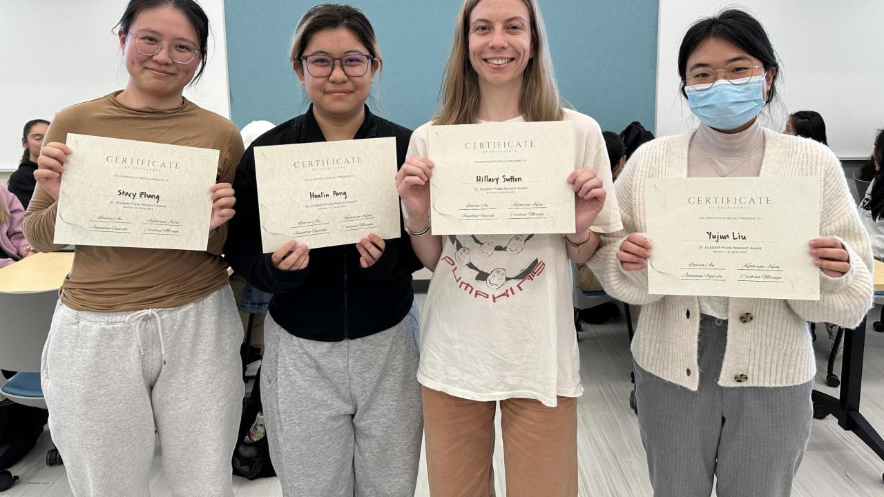 Four students holding up Dr. Elizabeth Prado Research Award certificates